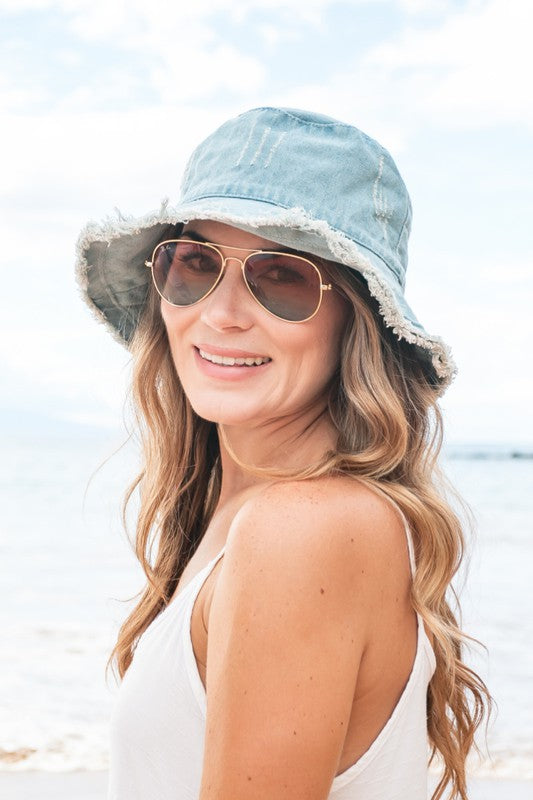 Head out in style with our denim bucket hats! Featuring a frayed edge and washed design, these are guaranteed to keep you ahead of the trend! Details: Trending Bucket Hat style Washed Denim Frayed Edges Internal Wire Brim for Perfect Styling One Size Fits Teen-Adult   Style: bucket hat, sunhat, denim  Embellishment: distressed