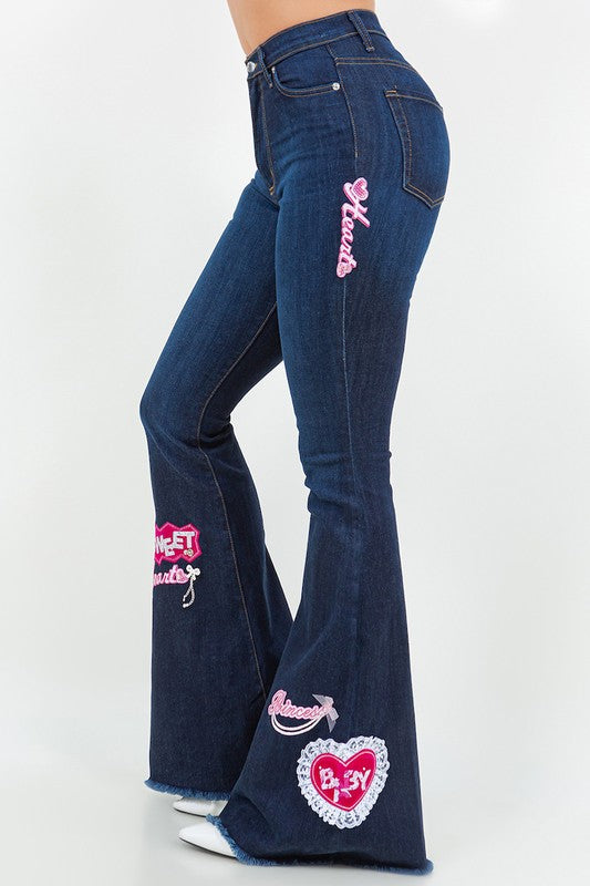 Step up your denim game with our Sweetheart Bell Bottom Jean in Dark Denim! These stylish jeans boast a flattering fit with front button and zipper closure, front and back pockets for convenience, and charming patch and charm details. Plus, they're made in the USA with premium fabrics for quality you can trust.
Patches pink
DRY CLEAN ONLY.

Silhouette: Bell bottom

Fit: High RIse

Embellishment: Patches, cahrms

Length: Full Length

Closure: button, zipper


Made In: USA