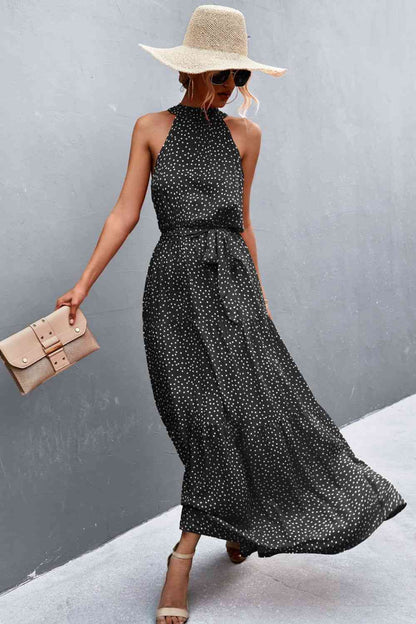 This Printed Sleeveless Tie Waist Maxi Dress is an ideal choice for both casual and formal occasions. Featuring a sleeveless design, the dress is perfect for wearing during the spring and summer months. However, it can also be layered for cooler weather in the fall and winter. Its flattering tie waist provides a stunning silhouette that you’ll love. black